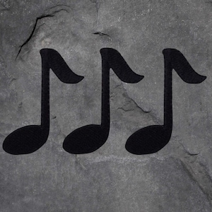 Könnte beinhalten: Drei schwarze Musik-Achtelnoten vor einem strukturierten, grauen Steinhintergrund. Die Noten haben einen abgerundeten Körper und eine gebogene Fahne. Der Hintergrund hat ein raues, verwittertes Aussehen.