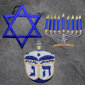 May include: A blue Star of David, a blue and white dreidel, and a menorah with nine blue candles. The menorah is made of gold metal and has a silver base.