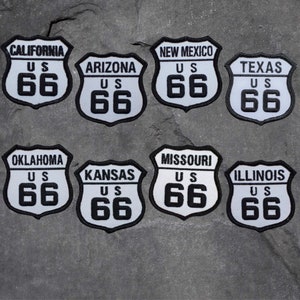May include: Ten white and black Route 66 patches with the text "US 66" and the state name. The patches are arranged in two rows of five.