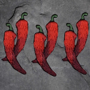 May include: Six red chili pepper patches with green stems are arranged on a gray background. The patches are embroidered with a textured appearance, showcasing a gradient of red hues. The peppers are a vibrant decorative element.