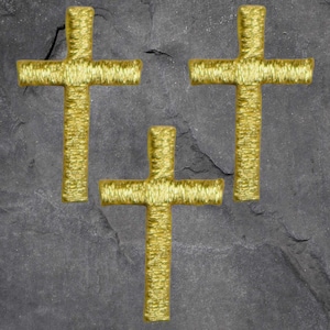 May include: Three gold embroidered crosses on a gray stone background.