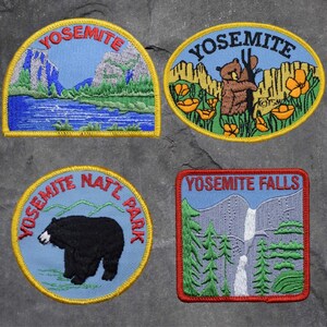 May include: Four embroidered patches featuring the Yosemite National Park logo. The patches are yellow, blue, and green with the words "Yosemite National Park", "Yosemite Falls", and "Yosemite" on them.