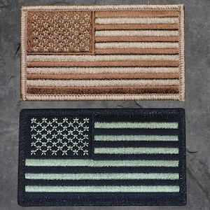 May include: Two embroidered American flag patches. The top patch is tan with brown stitching. The bottom patch is black with green stitching.