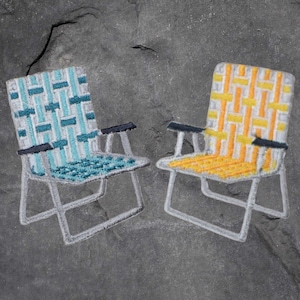 May include: Two folding chairs, one with a blue and white striped pattern and the other with a yellow and white striped pattern. Both chairs are made of metal and have a simple design.