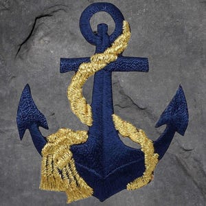 May include: Embroidered navy blue anchor patch with gold rope detail. The nautical design features a classic anchor shape with intricate stitching, perfect for adding a maritime touch to clothing or accessories. The patch is set against a textured gray background.