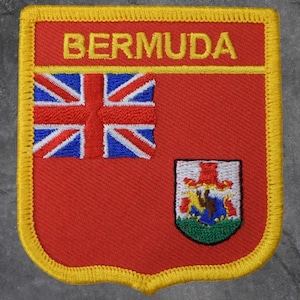May include: A red Bermuda patch with a yellow border. The patch features the word "BERMUDA" in yellow, a Union Jack flag, and a coat of arms. The patch is likely an embroidered emblem.