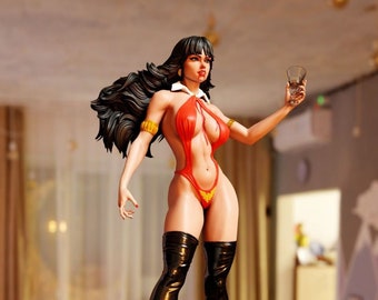 May include: A red and black figurine of a woman with long black hair, wearing a red bodysuit and black boots. She is holding a glass of liquid in her right hand. The figurine is standing on a black base with a gold trim and a gold phoenix logo.