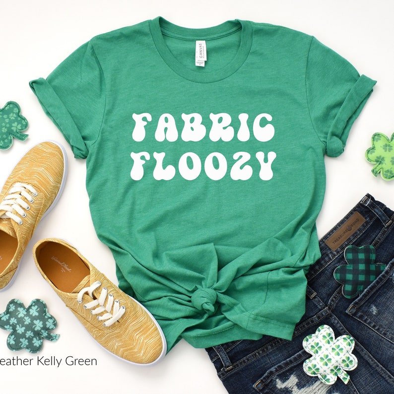 Pu&ograve; includere: Una maglietta verde Heather Kelly Green con la scritta bianca "FABRIC FLOOZY", annodata in vita. Sono presenti anche scarpe da ginnastica gialle, pantaloncini di jeans e decorazioni a forma di quadrifoglio.