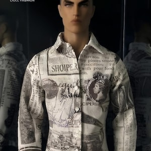 May include: A long-sleeved button-down shirt featuring an off-white base with a black and grey newspaper-style print. The pattern includes various text blocks, illustrations, and a profile portrait. The shirt has a classic collar and white buttons.