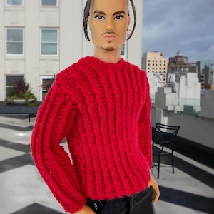 May include: A red knitted sweater with a ribbed texture. The sweater has long sleeves and a crew neck.