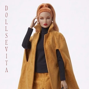 May include: A fashion doll with long ginger hair styled in a high ponytail, wearing a dark gray turtleneck sweater under a mustard yellow suede-textured cape. The text DOLLSEVITA is printed vertically in red on the left side of the image.