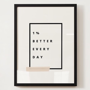 Pu&ograve; includere: Stampa incorniciata con la scritta "1% BETTER EVERY DAY" in nero su sfondo bianco. La stampa &egrave; racchiusa in una cornice nera, con un piccolo rettangolo beige in basso al testo.