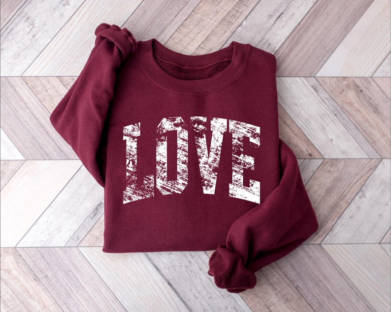 A burgundy sweatshirt with the word "LOVE" printed in white text on the front.
