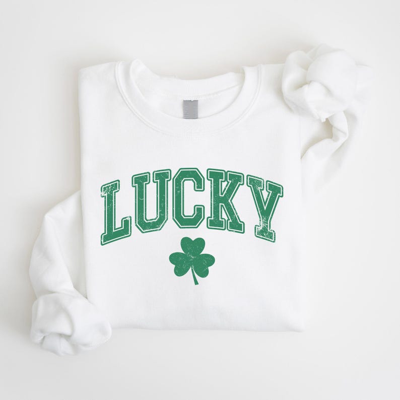 a white t - shirt with a green lucky shamrock on it