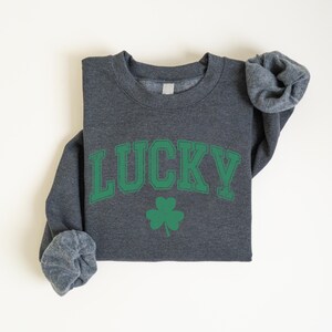 a gray shirt with a green lucky on it