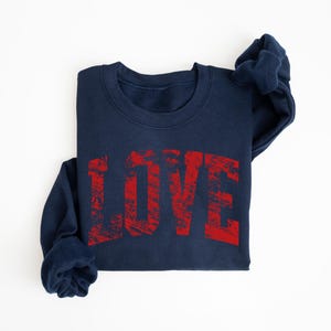 A navy blue sweatshirt with the word "LOVE" printed in red text on it.