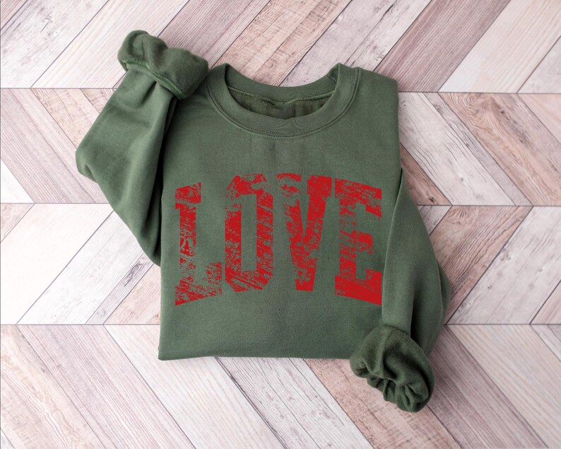 A green sweatshirt with the word "LOVE" printed in red text on it.