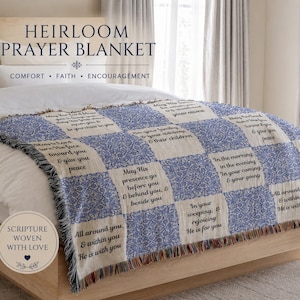 May include: A blue and white Heirloom Prayer Blanket with inspirational scripture woven throughout. The blanket features a patchwork design with floral patterns and fringed edges. The text on the blanket includes phrases like "May His presence go before you" and "He is with you."