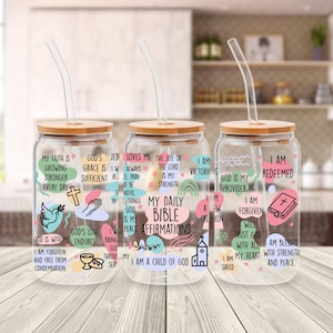 May include: Three glass drinking jars with bamboo lids and clear straws. Each jar has a different design with inspirational text and graphics, including crosses, doves, and rainbows. The text includes phrases like "My Daily Bible Affirmations."