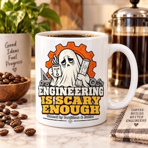 May include: A white ceramic mug featuring a graphic of a ghost holding a coffee cup labelled Plan B and a blueprint. The text reads Engineering Is Scary Enough and Powered by Deadlines & Coffee. The design includes an orange gear and metal nuts.