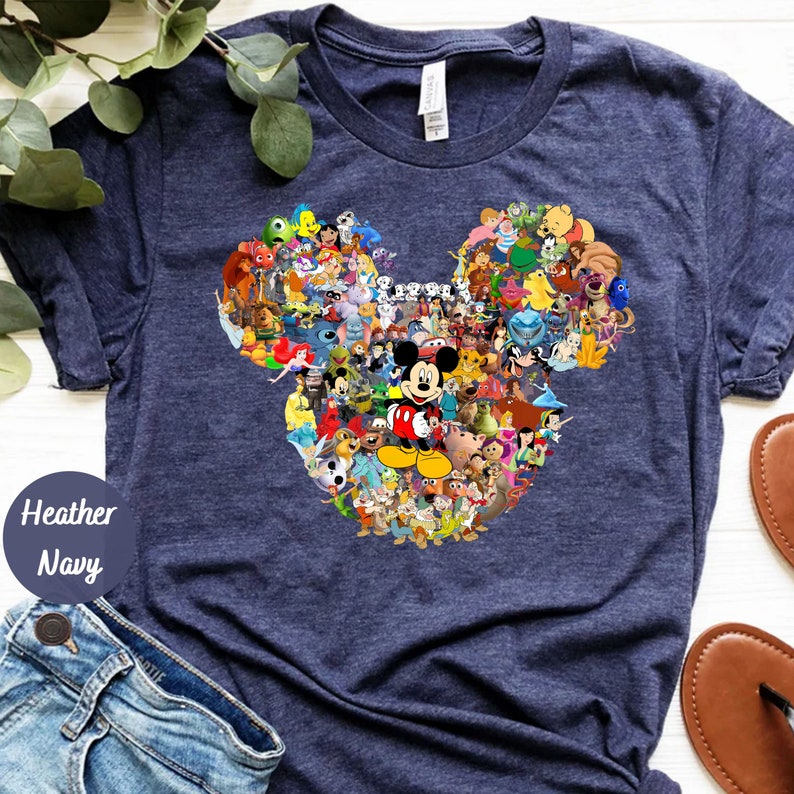 May include: A navy blue t-shirt with a graphic of Mickey Mouse's head made up of various Disney characters. The characters include Mickey Mouse, Minnie Mouse, Donald Duck, Goofy, Pluto, and many more.