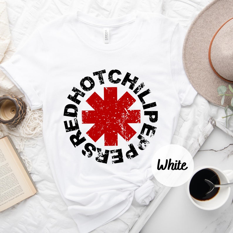 May include: White t-shirt with a black and red graphic of the Red Hot Chili Peppers logo. The logo is a red star with a black outline and the words "Red Hot Chili Peppers" written around it.