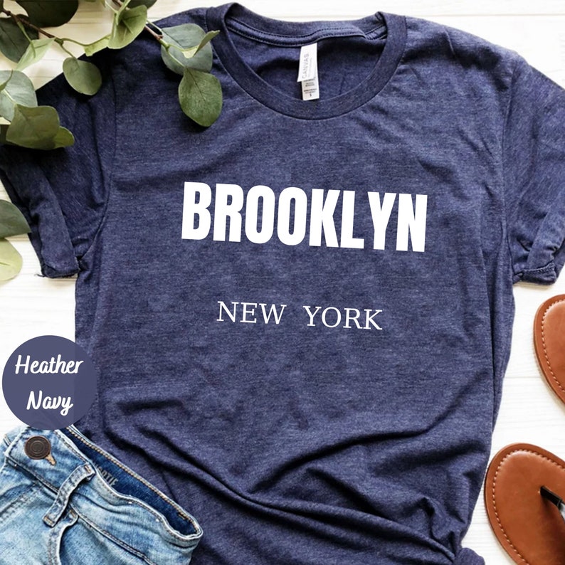 May include: A heather navy blue t-shirt with white text that reads "BROOKLYN NEW YORK".
