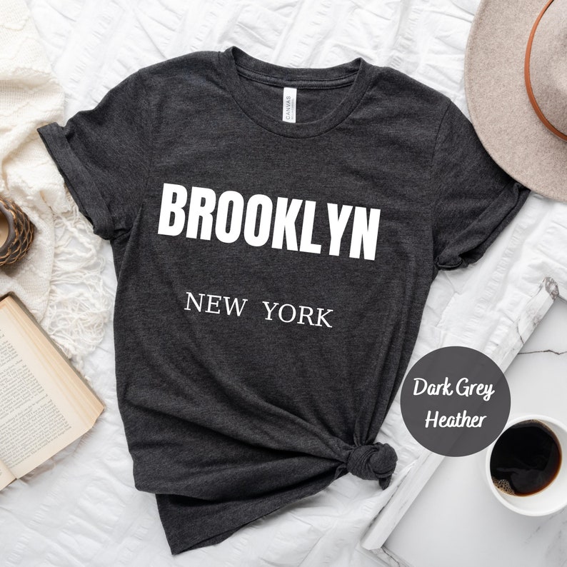 May include: Dark grey heather t-shirt with white text that reads "BROOKLYN NEW YORK".