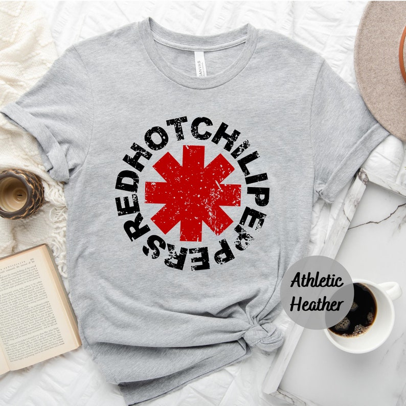 May include: Gray t-shirt with a red and black Red Hot Chili Peppers logo. The logo is a red star with a black outline and the words "Red Hot Chili Peppers" around it. The shirt is labeled "Athletic Heather".