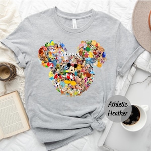 May include: A gray t-shirt with a Mickey Mouse silhouette made up of various Disney characters. The text "Athletic Heather" is printed on the bottom right corner of the shirt.