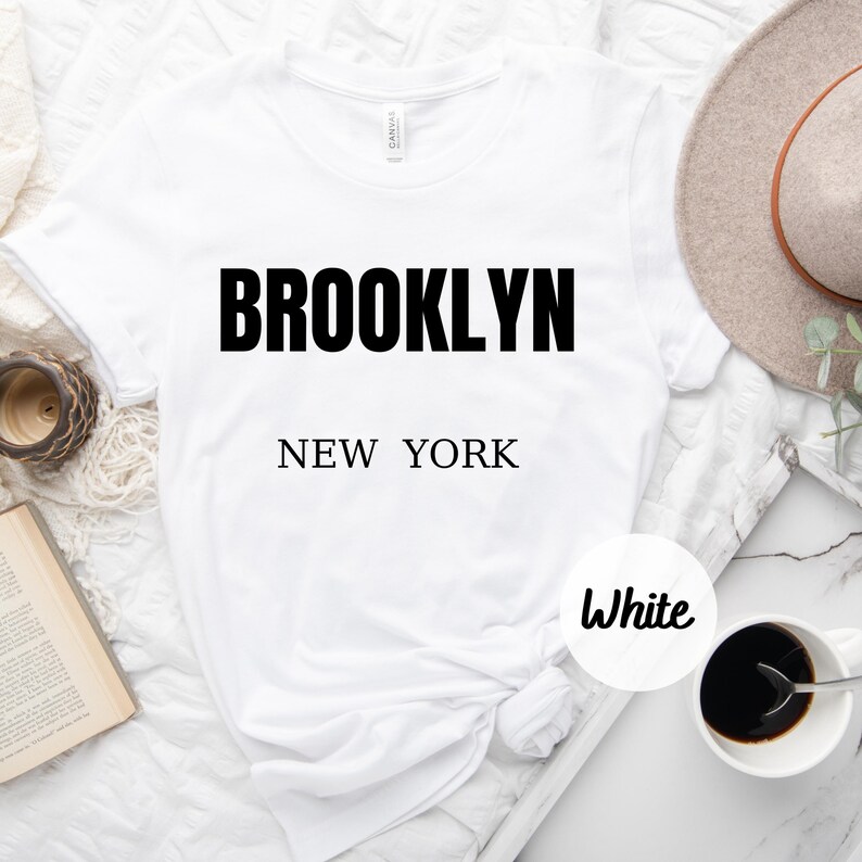 May include: White t-shirt with black text that reads "BROOKLYN NEW YORK" and a white circle with the word "White" in black text.