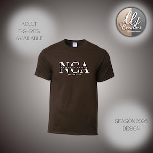 May include: A brown t-shirt with the white text "NCA DANCE STUDIO SEASON 2026" printed on the front. The words "ADULT T-SHIRTS AVAILABLE" are above the shirt. The design also includes the text "SEASON 2026 DESIGN".