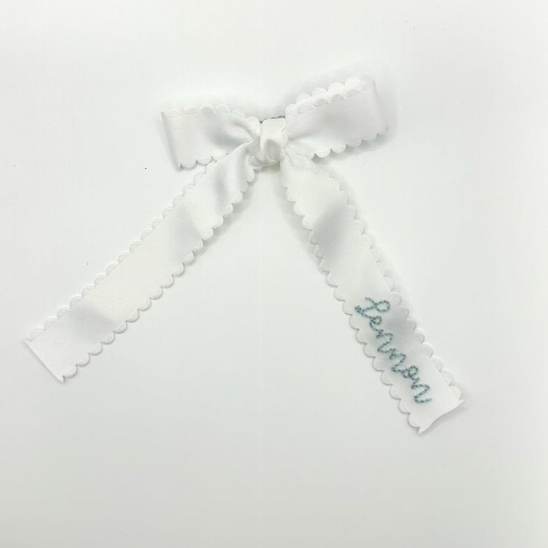 Peut inclure: Noeud en ruban de satin blanc avec des bords festonn&eacute;s et le nom "Lemon" brod&eacute; en fil bleu.