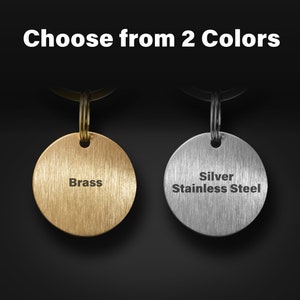 May include: Two keyrings with round metal tags. The tag on the left is brass and says "Brass". The tag on the right is silver stainless steel and says "Silver Stainless Steel".