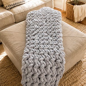 Beginner-friendly chunky hand knit blanket video tutorial by Wistfully Woven featuring the Rustic Barn Weave stitch pattern in a soft sky blue color. Digital PDF download includes a 15+ minute step-by-step YouTube tutorial teaching how to make a cozy chunky knit blanket from cast on to cast off.