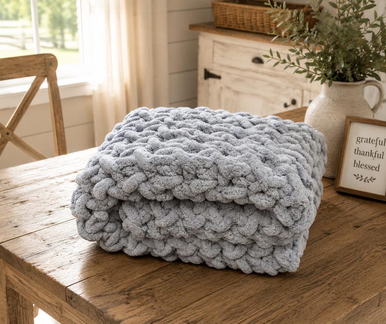 Beginner-friendly chunky hand knit blanket video tutorial by Wistfully Woven featuring the Rustic Barn Weave stitch pattern in a soft sky blue color. Digital PDF download includes a 15+ minute step-by-step YouTube tutorial teaching how to make a cozy chunky knit blanket from cast on to cast off.