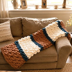 Beginner-friendly chunky hand knit blanket video tutorial by Wistfully Woven featuring the Rustic Barn Weave stitch pattern in a soft sky blue color. Digital PDF download includes a 15+ minute step-by-step YouTube tutorial teaching how to make a cozy chunky knit blanket from cast on to cast off.