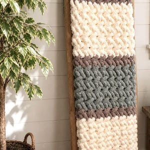 Beginner-friendly chunky hand knit blanket video tutorial by Wistfully Woven featuring the Rustic Barn Weave stitch pattern in a soft sky blue color. Digital PDF download includes a 15+ minute step-by-step YouTube tutorial teaching how to make a cozy chunky knit blanket from cast on to cast off.