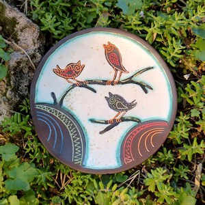 handmade bird ceramic plate on green grass natural setting decor