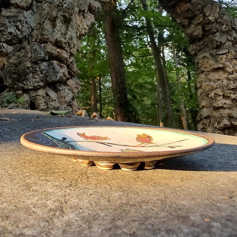 low angle ceramic bird plate on stone surface artistic perspective