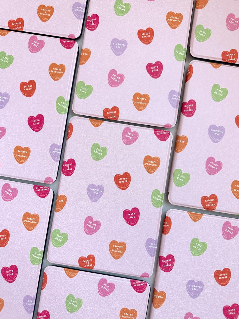 Puede incluir: Un juego de ocho posavasos rosas con fondo blanco y un patr&oacute;n repetido de caramelos en forma de coraz&oacute;n de colores con diferentes lemas. Los lemas incluyen "Soul Mates", "Second Chance", "Found Family", "Grumpy & Jealous", "Insta Love", "Forced Proximity", "Slow Burn", "Free Dating", "Enemies to Lovers", "Pre-Pregnant", "Friends to Lovers", "Karma to Lovers", "Loveas", "Fare Rating", "What", "100% Mates".