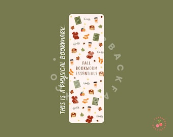 May include: A rectangular bookmark with a cream background and a fall-themed design. The design includes illustrations of glasses, coffee cups, sweaters, books, leaves, and the text "FALL BOOKWORM ESSENTIALS". The text "THIS IS A PHYSICAL BOOKMARK" is also present.