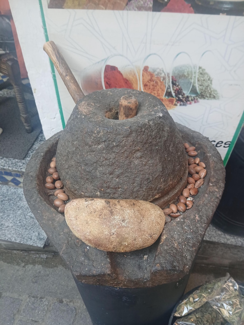 Traditional Moroccan stone grinder used for extracting argan oil, authentic handmade production process