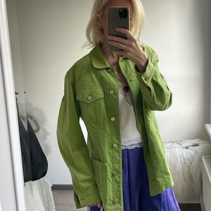 May include: A lime green button-down jacket featuring a classic collar, long sleeves with buttoned cuffs, two chest pockets with buttoned flaps, and metallic gold-toned buttons running down the center front placket.