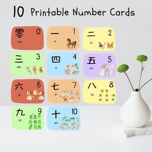 May include: Printable number cards featuring numbers 0-10 in Chinese characters and English transliterations. Each card has a different color background and includes illustrations of animals and objects representing the number.