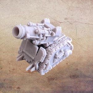 Può includere: Un modello di carro armato in plastica grigia con un grosso cannone. Il carro armato ha i cingoli e un design dettagliato.