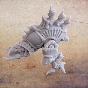 Peut inclure: Une figurine miniature grise et détaillée, probablement pour les jeux de société ou le modélisme. La figurine présente un design blindé avec des pointes, des rivets et des appendices en forme de griffes. L'esthétique générale suggère un thème de science-fiction ou de fantasy.