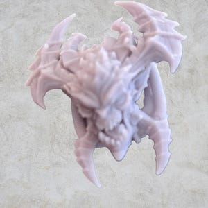 May include: A 3D printed, light gray, detailed sculpture of a demonic creature with sharp horns and fangs.