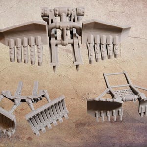 Può includere: Tre componenti di modello in plastica grigia, probabilmente per un veicolo in miniatura o un set di costruzione. Le parti includono una struttura centrale con bracci articolati e due attacchi a forma di lama, e un componente più piccolo con un design a forma di rastrello.