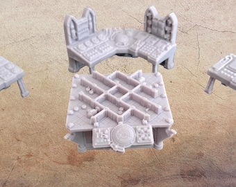 May include: A collection of gray miniature tables and consoles, likely for a tabletop game. The pieces have intricate details, including dials, buttons, and geometric patterns. One piece is a corner console, and another is a square table with a maze-like design.